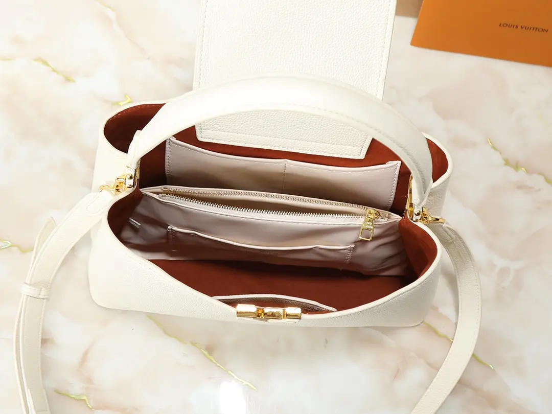 💰200💰广州货 顶级原版 M14370 M14371 M14979 本款 Capucines Souple 中号手袋取材细腻粒面牛皮革,以绒面内衬和耀目金属件映衬鲜明反差,再借 LV 字母抒写品牌传承。翻盖可内收或外置,隔层和口袋有序收纳日常所需,可随心切换多种背携方式。尺寸:33.0 x 24.0 x 12.0 厘米 (长 x 高 x 宽)
