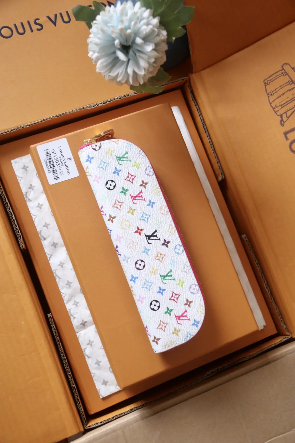 GI1081白花/GI1303白彩💕P140 - 主体为LV标志性Monogram老花帆布，拉链边缘拼接配色皮革/织物，金属拉链头刻有LV标识，撞色设计增添活泼感； ​ - 采用长条形弧形造型，贴合笔具收纳形态，内部空间可容纳多支笔、便签等小文具。