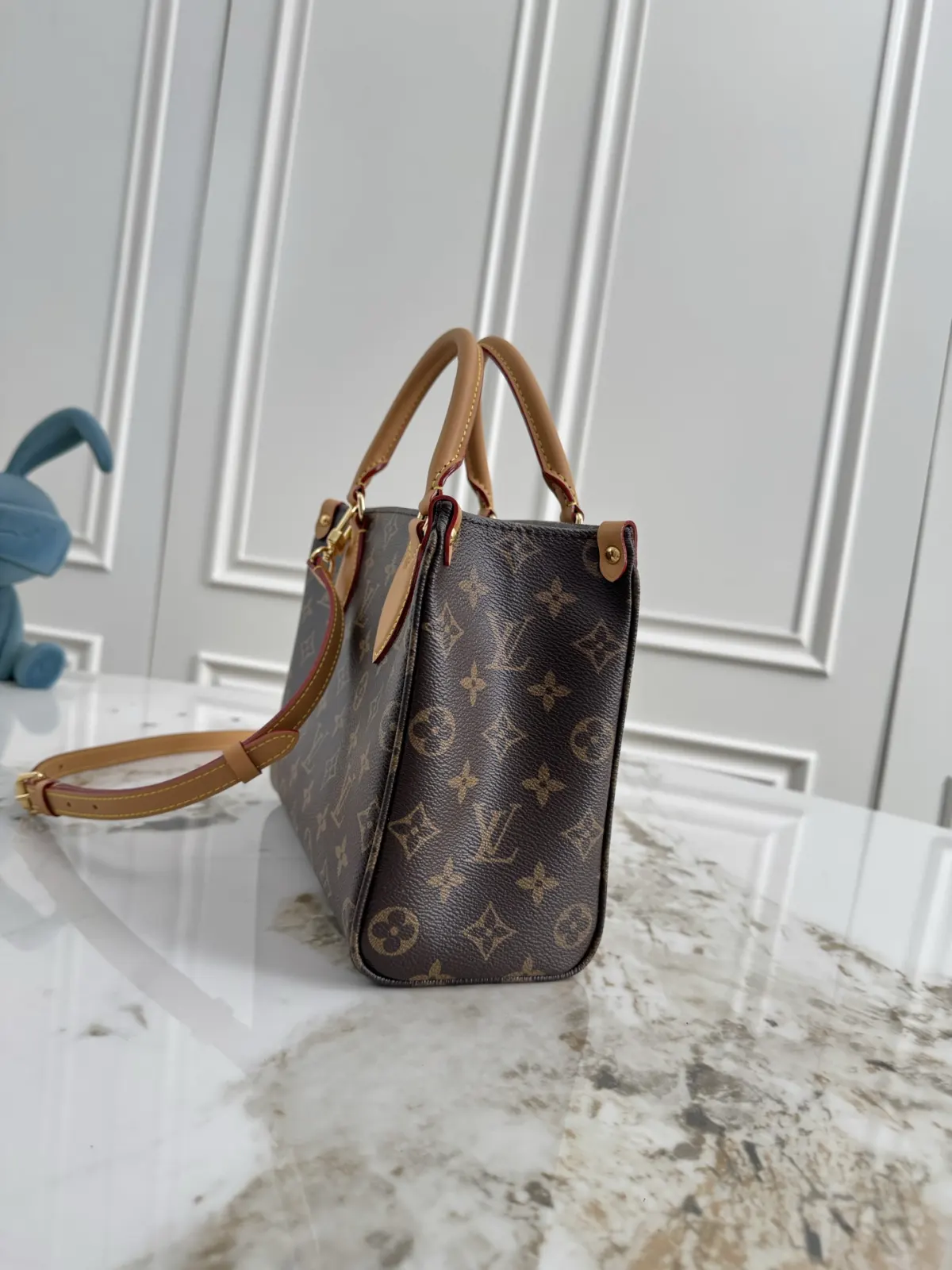 P370💰M3a026 本款M3A142大号LV26秋冬新款ONTHEGO 这款ONTHEGO SOFT托特包以垂感的现代廓形搭配精致编织链条焕新演绎，以老花帆布和老花压印小牛皮革精心制造，袋身以对比色皮革饰边及金色金属件，令精致细节更显升华，是完美的城市袋款，实用设计尺寸足以收纳书籍等日常必需品，而内置口袋可妥善收纳随身小物，配备可拆卸及可调节长度肩带，可作手提、肩背或斜跨造型，尽显时尚优雅 尺寸：25*19*11.5(长 高 宽)