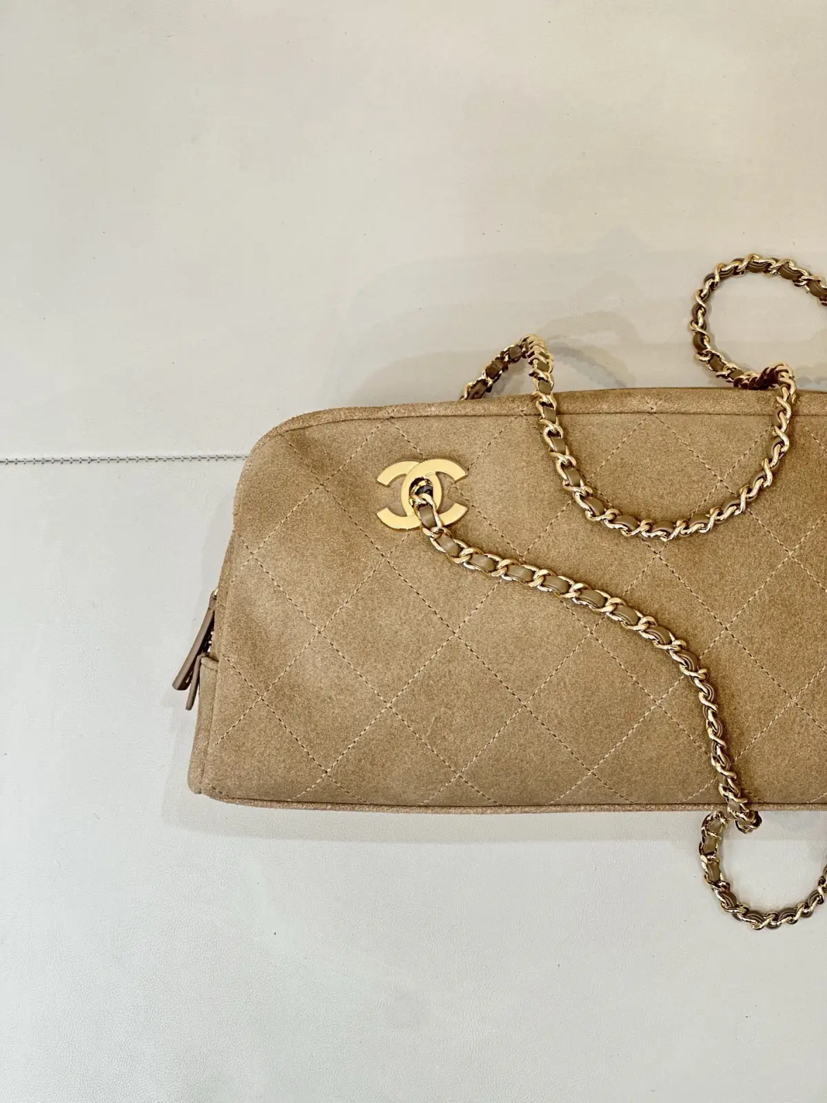 6406 Chanel 26A 新款麂皮腋下法棍包 \n秋冬一到麂皮款直接杀回来！这只香家卡其麂皮长法棍，真的属于越看越有味道的宝藏款，第一眼就被这个复古氛围感拿捏住。\n区别于常规单双C包款，包身左右对称双C金标设计，辨识度直接拉满。包身精选卡其麂皮面料，上手软糯细腻，菱格车线工整利落，纹路均匀饱满，不是廉麂皮能比的。\n包身两侧做拉链开合，拿取物品很方便，内里空间充足，手机、粉饼、钥匙通通装下。\n老渠道牛货！正单出来的麂皮质感真的不一样，皮料的绒感、菱格走线、五金的色泽，市面普通版本很难。不撞款的小众长法棍，偏爱复古麂皮的姐妹，这只闭眼入！\n尺寸15-32-8cm